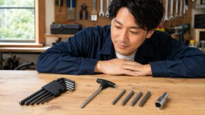 六角レンチセット、T型レンチ、ヘキサゴンソケットを作業台に並べて選び方を確認する日本人男性