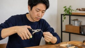 ペンチで針金を曲げる日本人男性のDIY作業イメージ
