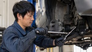 日本人整備士が車の足回りでソケットレンチを使い安全にナットを締める作業風景