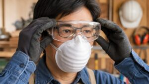 眼鏡対応の保護ゴーグルを装着しフィット感を確認する日本人作業者