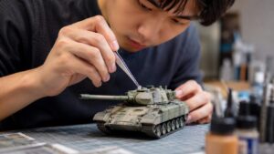 ピンセットで戦車模型の細かいパーツを取り付ける日本人男性