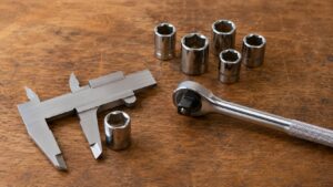 ノギスとラチェットハンドルとソケットを並べた工具サイズ確認の様子