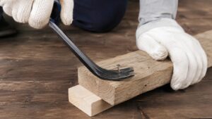 バールと当て木を使って木材から釘を抜くDIY作業