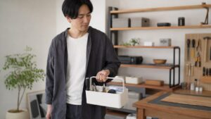 日本人男性が持ち手付き工具収納ボックスでDIY工具を運ぶ様子