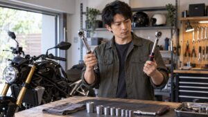 バイク用トルクレンチを比較する日本人整備士と作業台の工具